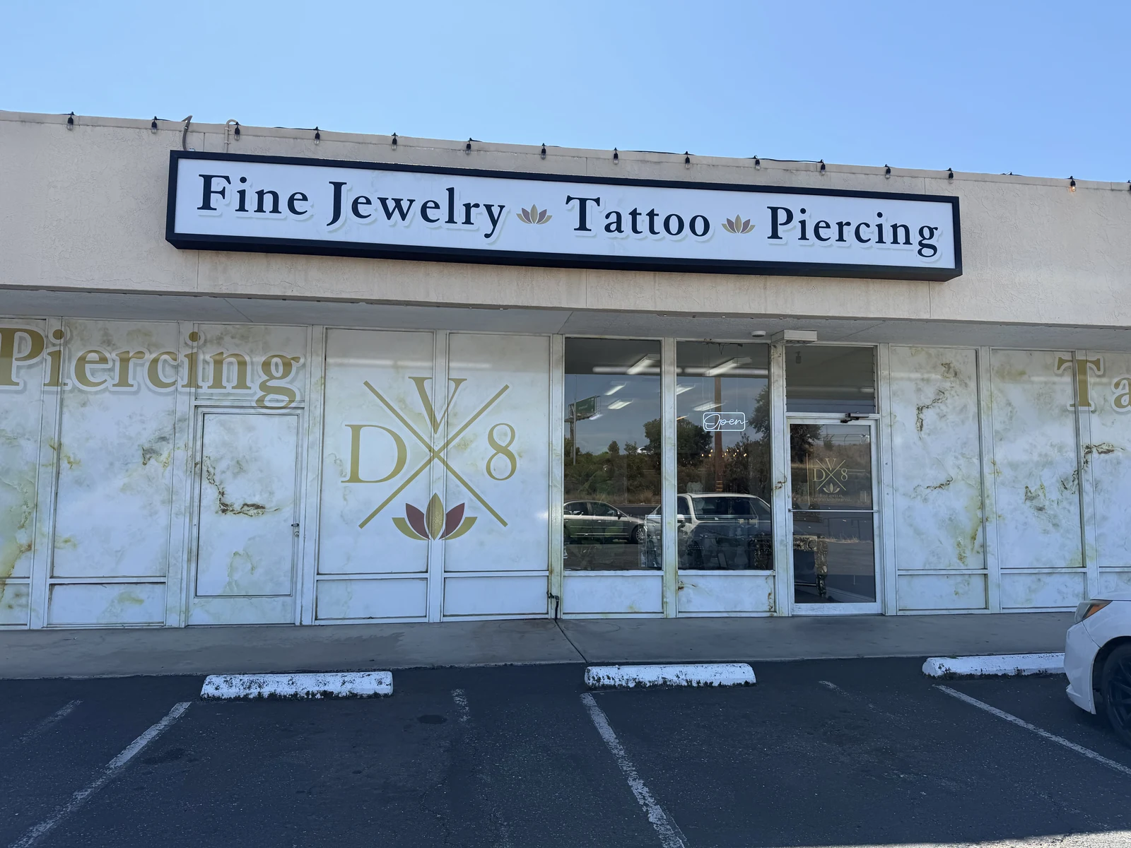 DV8 studio entrance with glass doors and the tattoo and piercing sign